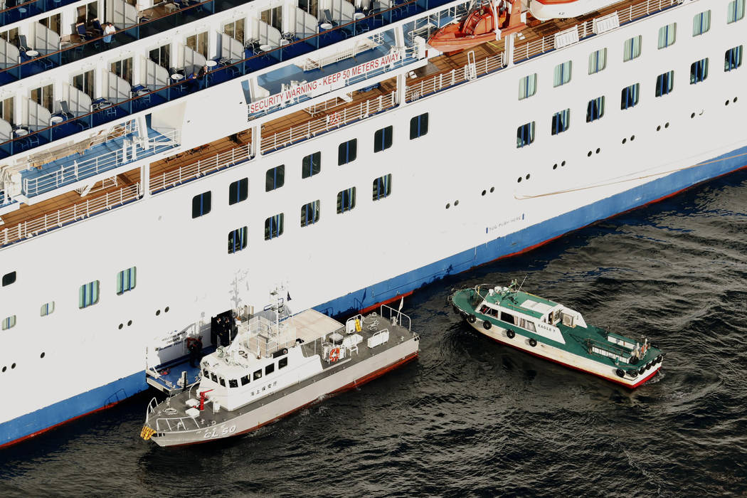 Japan Coast Guard's patrol boat, left, is brought alongside the cruise ship Diamond Princess to ...