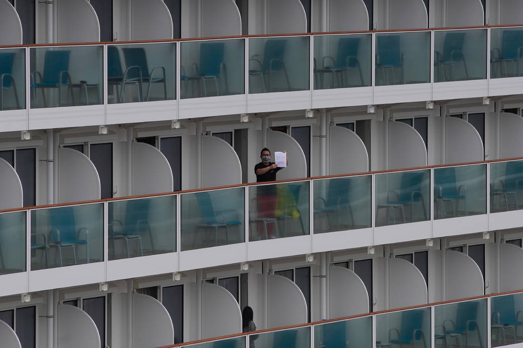 A passenger shows a note from the World Dream cruise ship docked at Kai Tak cruise terminal in ...