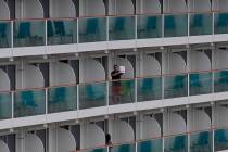 A passenger shows a note from the World Dream cruise ship docked at Kai Tak cruise terminal in ...