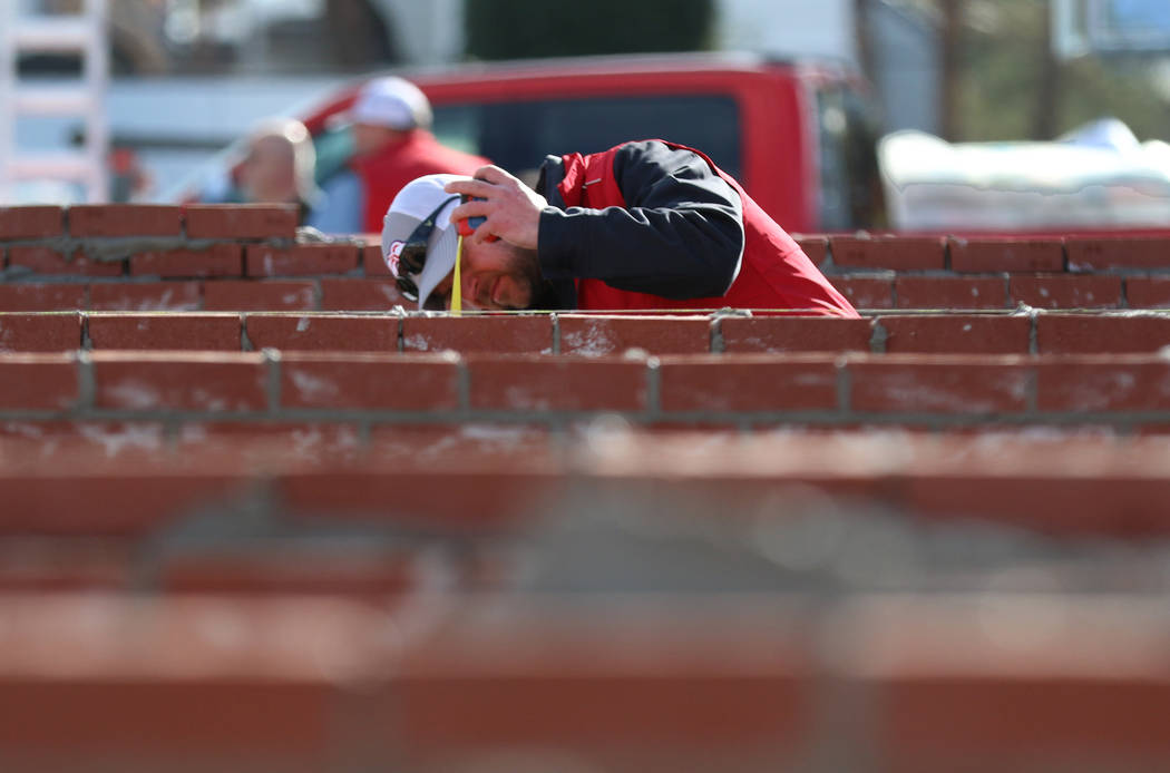 Judge David Pryes of Greenway, Wis, inspects a brick wall during the 2020 Spec Mix Bricklayer 5 ...