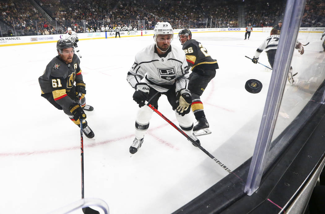 Golden Knights' Mark Stone (61) and Los Angeles Kings' Alec Martinez (27) watch the puck during ...