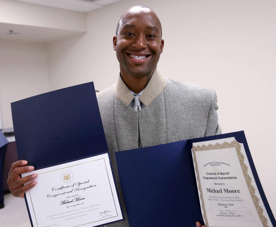 Michael Moore shows Congressional certificates during his Renewing Hope program graduation cere ...