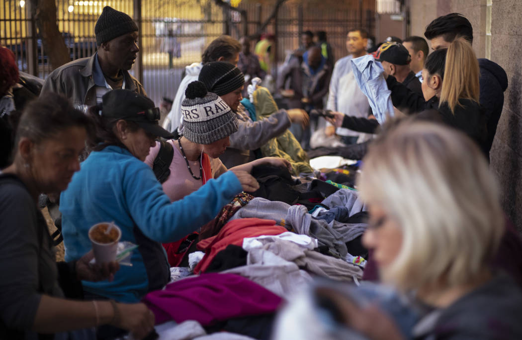 Homeless individuals sift through donated clothing after eating dinner at the Las Vegas Rescue ...