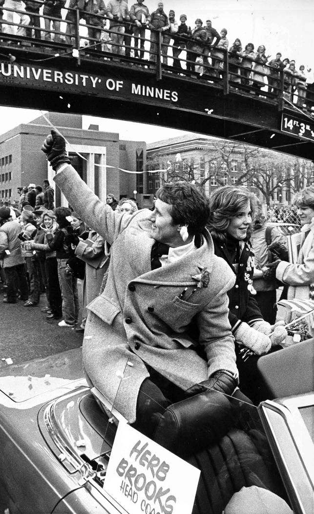 Olympic hockey coach Herb Brooks waves to the crowd as confetti flies in Minneapolis, Feb. 27, ...