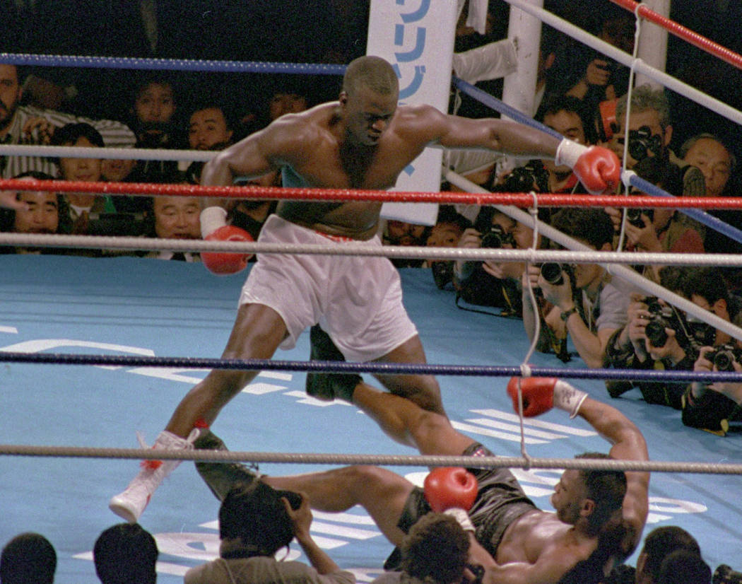 Challenger James "Buster" Douglas, stands over champion Mike Tyson who fell on his back after t ...