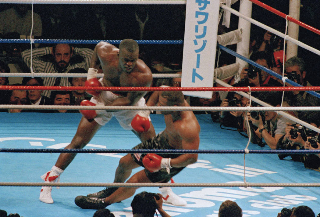 FILE - In this Feb. 11, 1990, file photo, James Douglas, left, follows with a left, dropping Mi ...