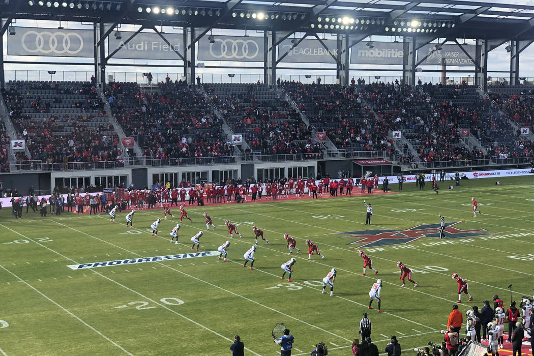 The D.C. Defenders, right, line up against the Seattle Dragons for the opening kickoff of the o ...