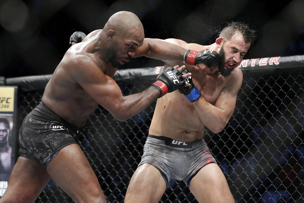 Jon Jones, left, connects with a punch to the face of Dominick Reyes, right, during a light hea ...