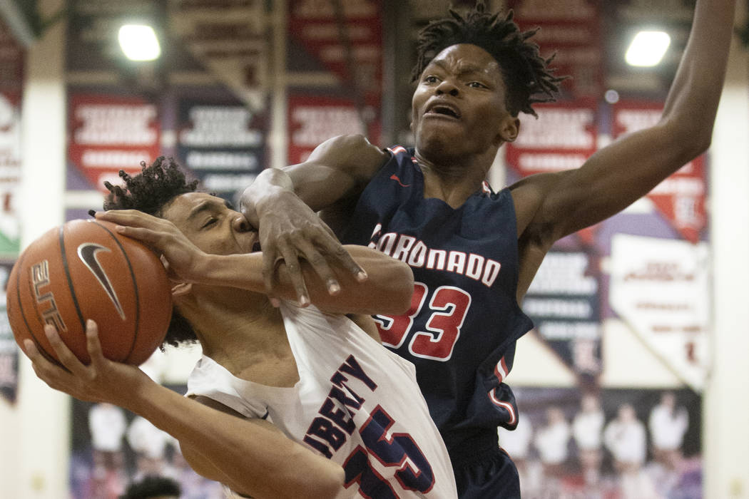 Liberty junior forward Greyson Montgomery (15) gets fouled on the way to the rim by Coronado so ...