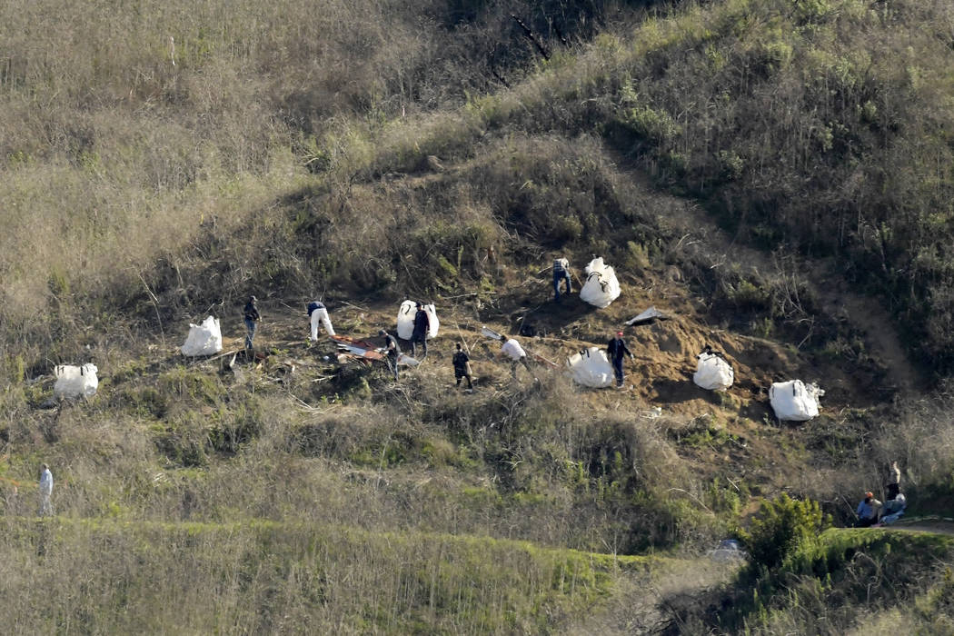 FILE - In this Tuesday, Jan. 28, 2020, file photo, investigators work at the scene of a helicop ...