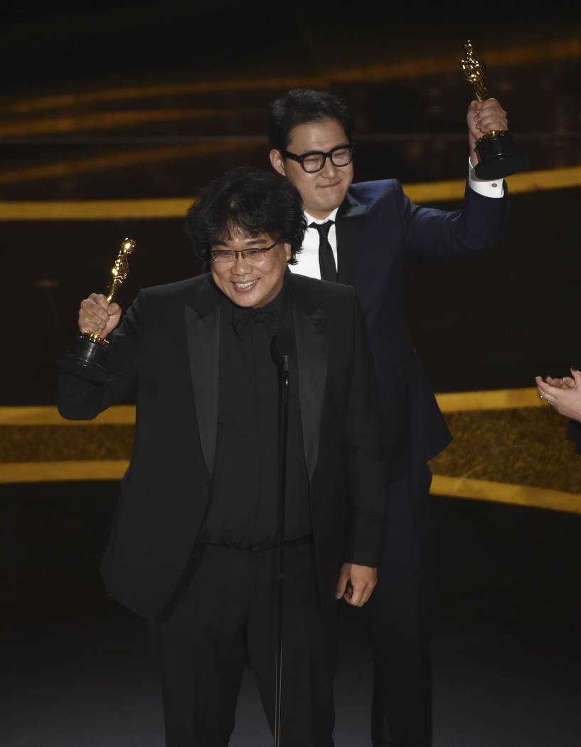 Bong Joon Ho, left, and Han Jin Won accept the award for best original screenplay for "Par ...