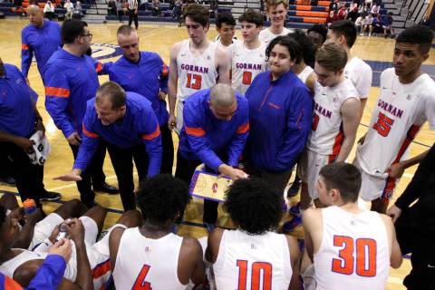 Bishop Gorman coaches talk to their players before the start of the fourt quarter of their bask ...