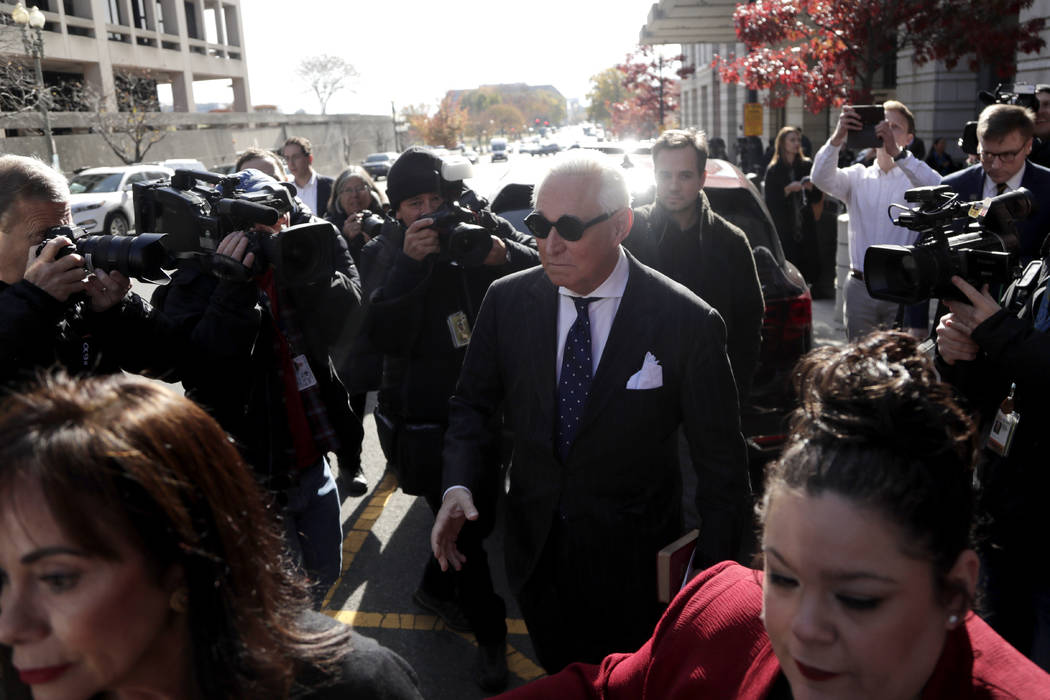 Roger Stone, center, is swarmed by reporters while leaving federal court in Washington, Friday, ...