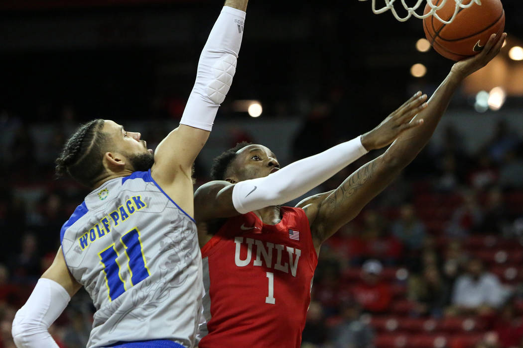 UNLV Rebels guard Kris Clyburn (1) takes a shot while under pressure from UNR Wolf Pack forward ...