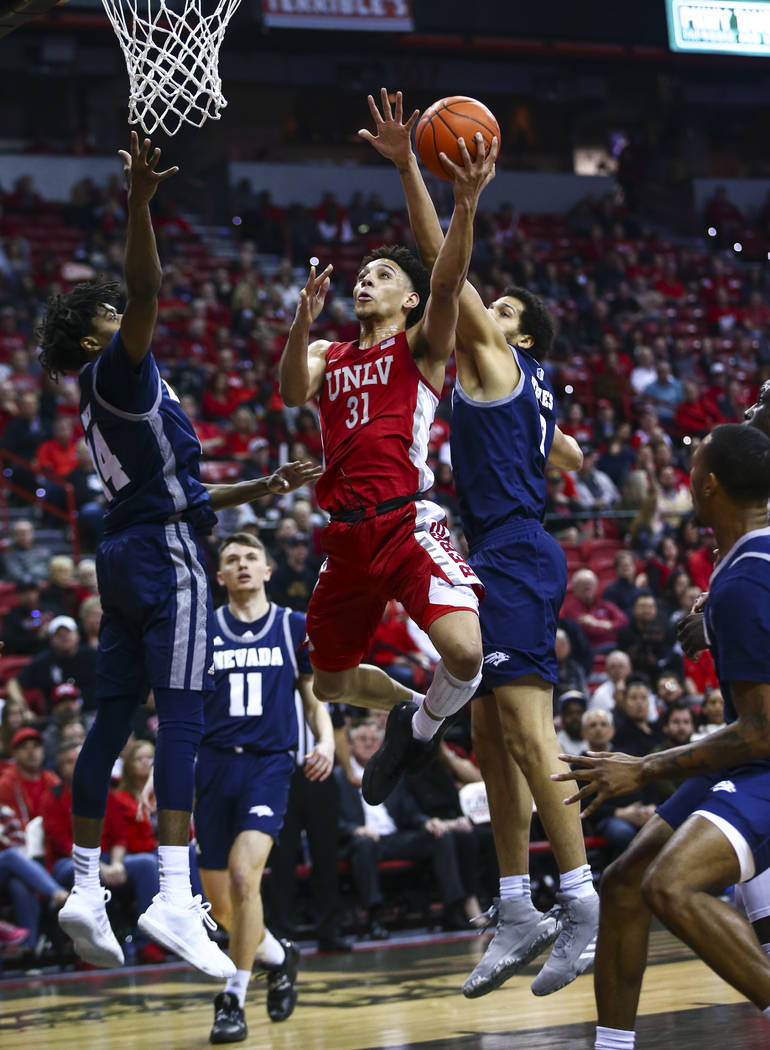 UNLV's Marvin Coleman (31) goes to the basket between UNR's Lindsey Drew (14) and Johncarlos Re ...