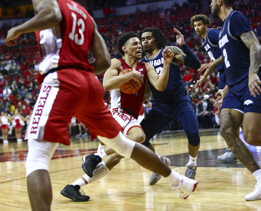 UNLV's Marvin Coleman (31) drives to the basket against UNR's Jazz Johnson (22) during overtime ...