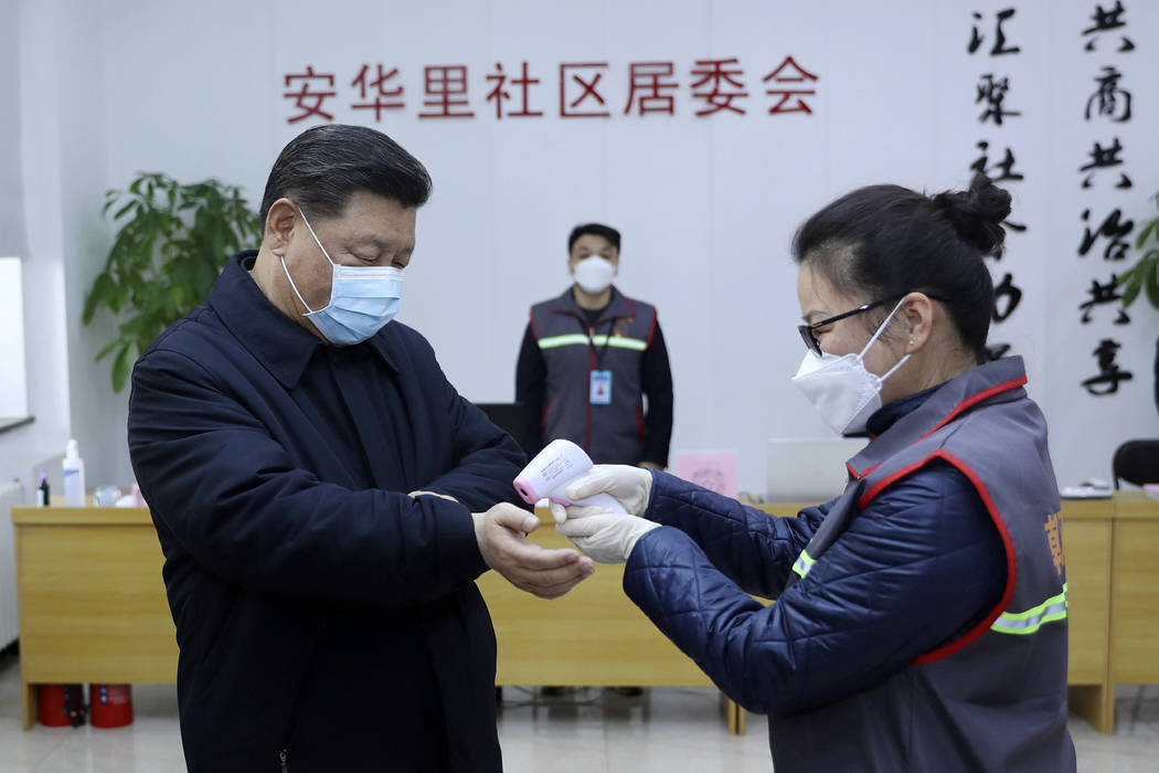 In this photo released by Xinhua News Agency, Chinese President Xi Jinping, left, wearing a pro ...