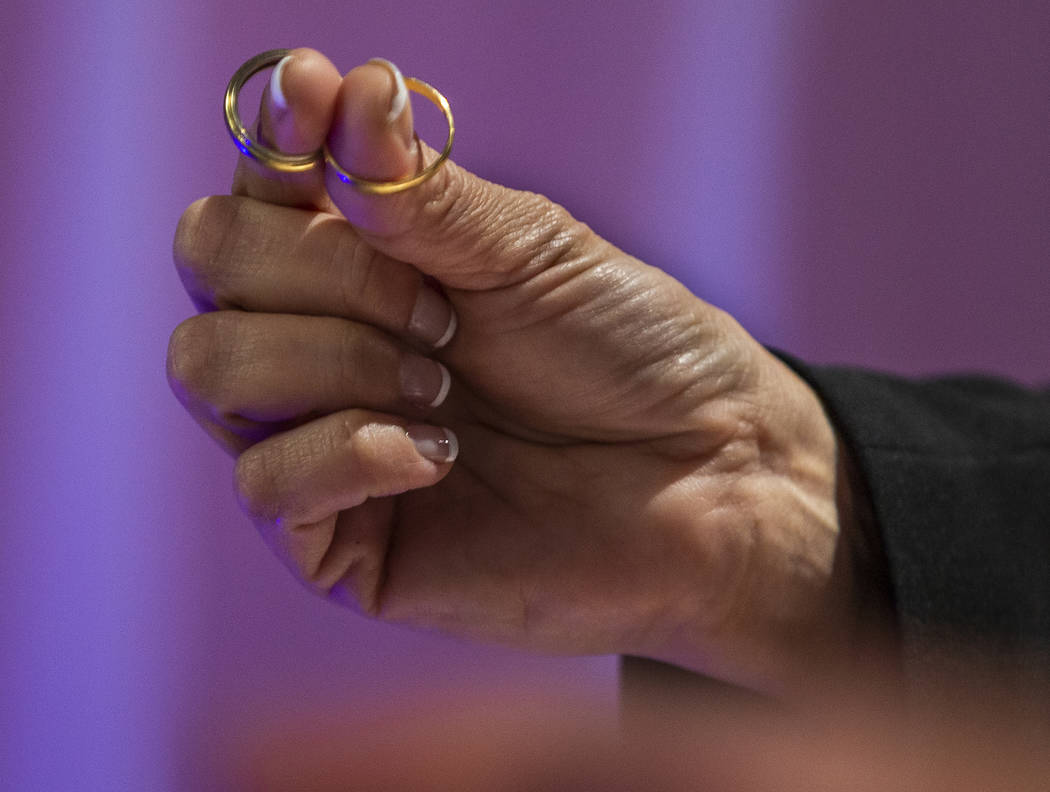 The Rev. Diana Moran holds the rings of Corrine and Aristide Justeau visiting from France as sh ...