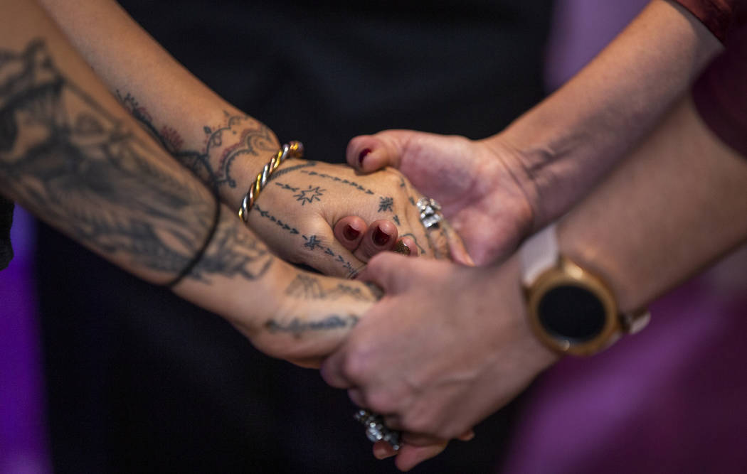 Coral Newberry and Serena Anderson hold hands during a friendship ceremony in the Chapel Diane ...
