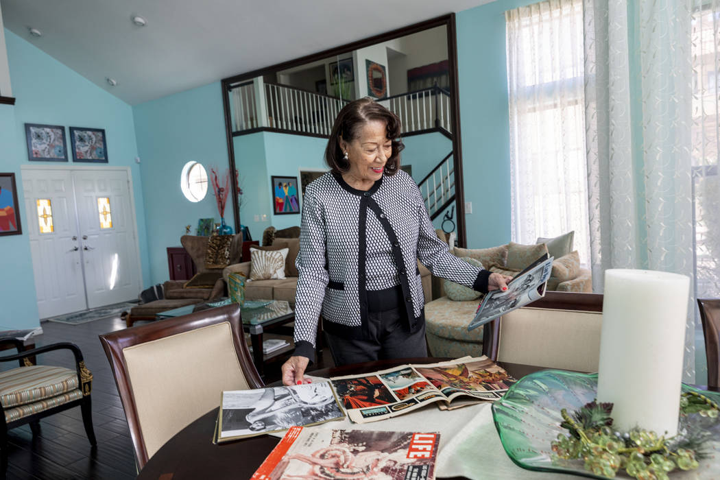 Moulin Rouge dancer Anna Bailey looks at her photographs printed in Life Magazine, in her home ...
