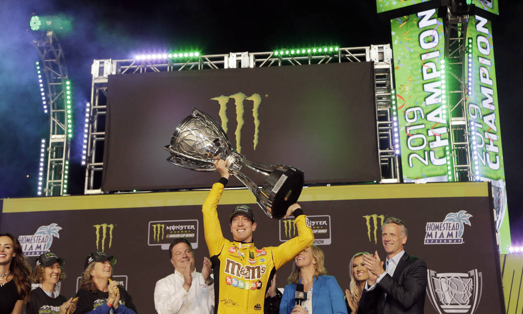 FILE - In this Nov. 17, 2019, file photo, Kyle Busch, center, holds up his trophy in Victory La ...