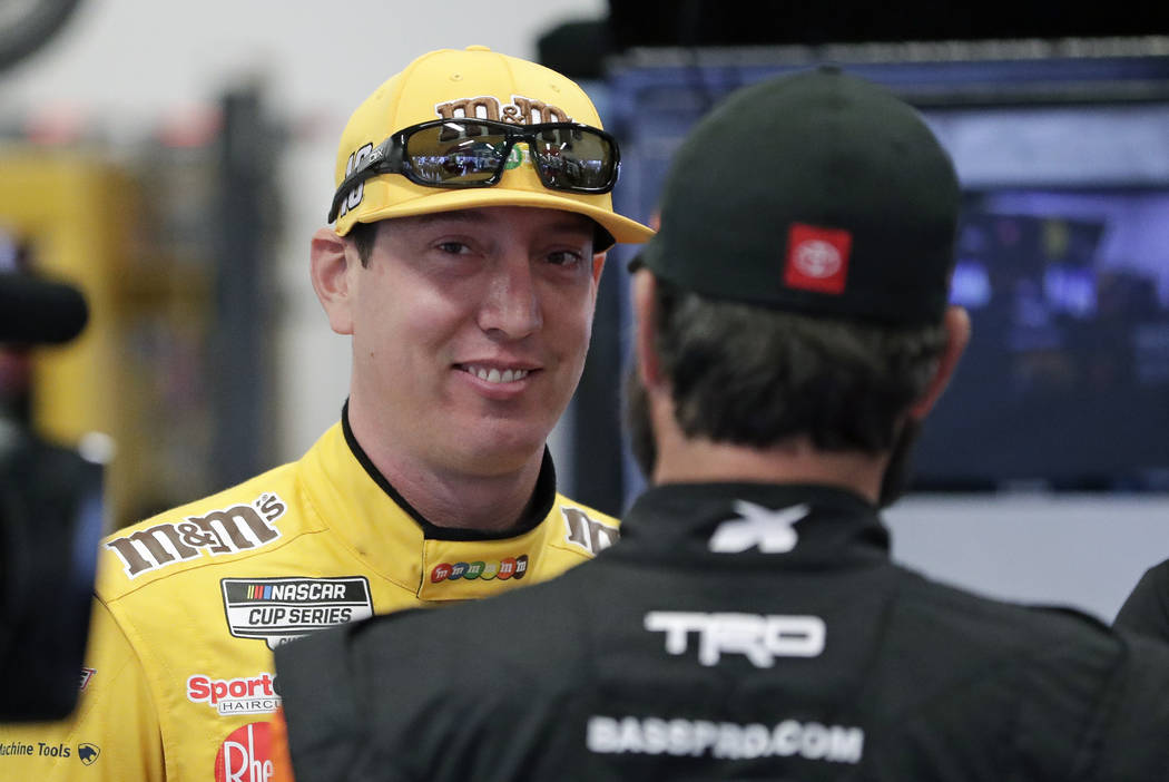 Kyle Busch, left, talks with Martin Truex Jr. in his garage during practice for the NASCAR Dayt ...