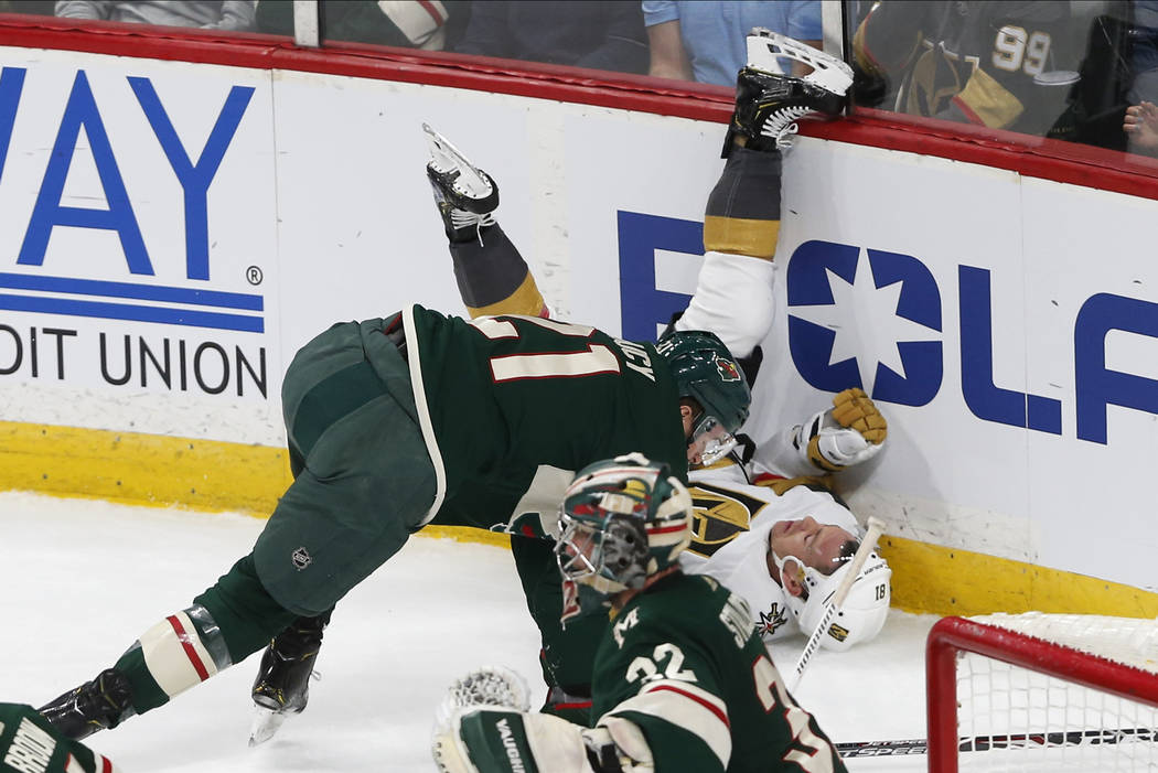 Minnesota Wild's Carson Soucy, left checks Vegas Golden Knights' Jonathan Marchessault to the i ...