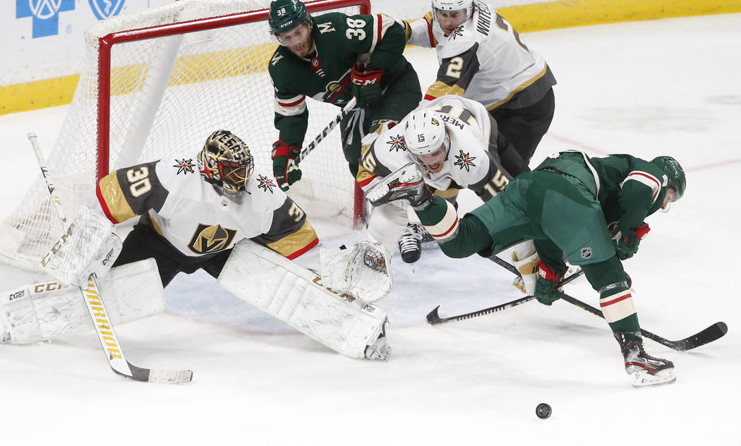 Minnesota Wild's Ryan Donato, right, gets tangled up with Vegas Golden Knights' Jon Merrill, ce ...