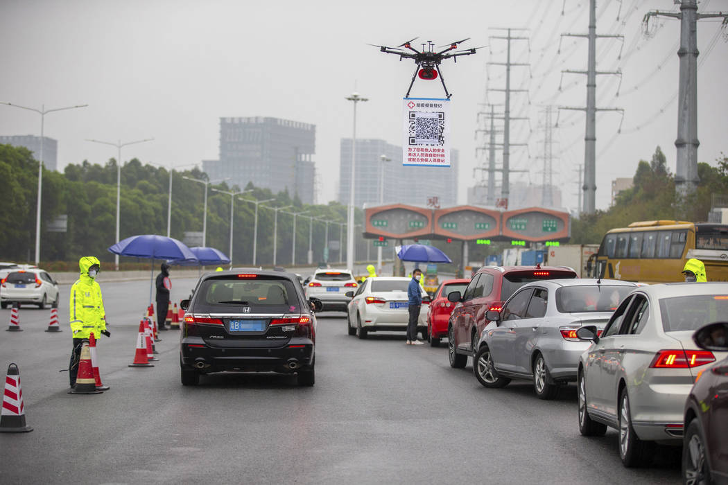 In this Tuesday, Feb. 11, 2020, photo released by China's Xinhua News Agency, a drone carries a ...