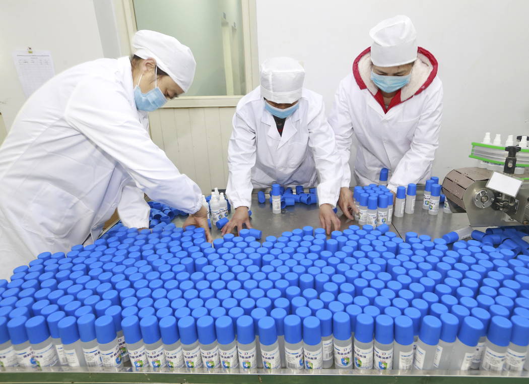 Workers pack bottles of alcohol disinfectant in a factory in Suining in southwest China's Sichu ...