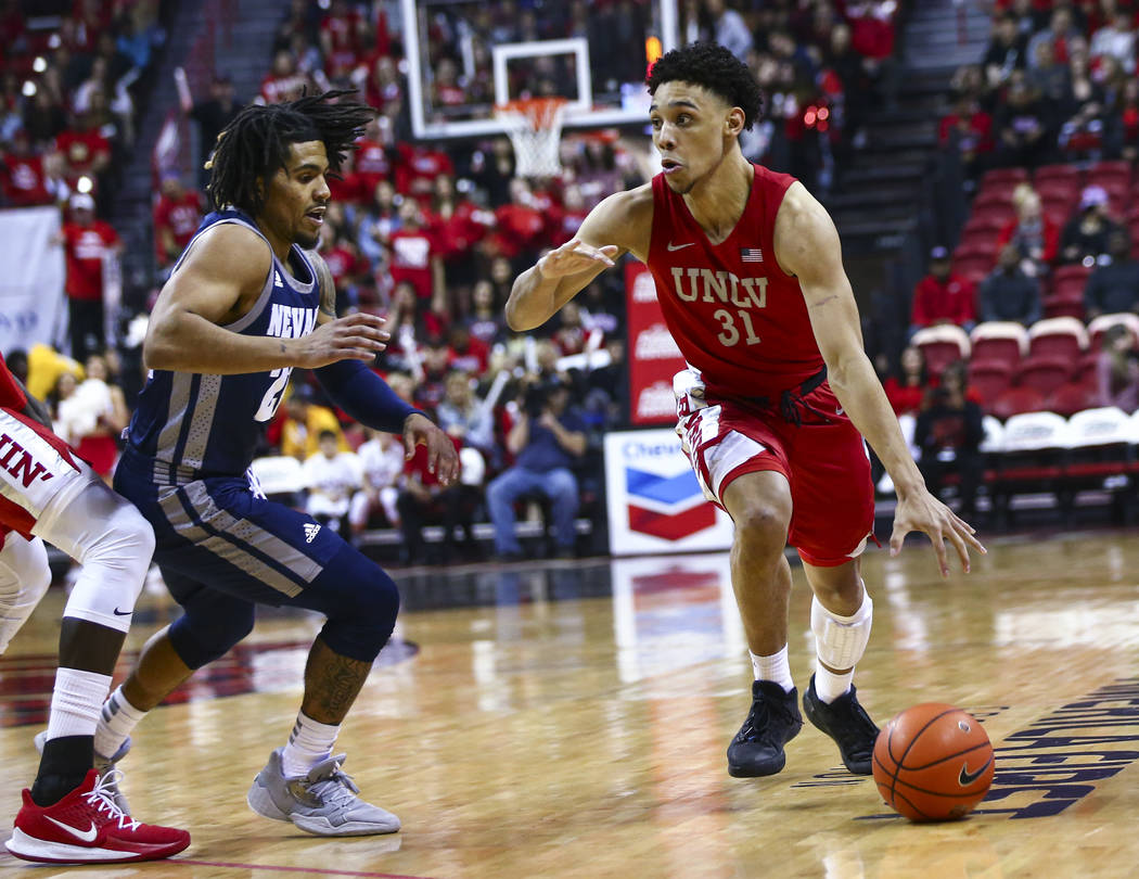 UNLV's Marvin Coleman (31) drives to the basket against UNR's Jazz Johnson (22) during the firs ...