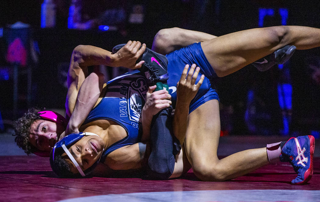 McQueen's Jahaun Hicks, left, wraps up Spring Valley's Ryan Mitchell on the mat in their 113 po ...