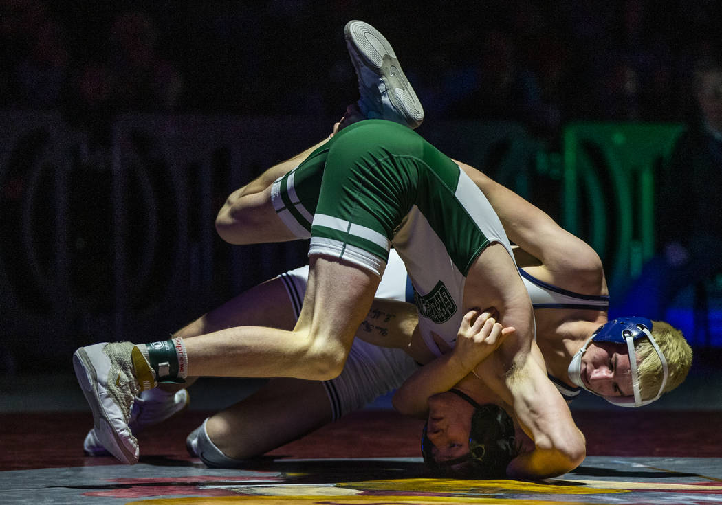 Green Valley's Jeremy Hoffman, left, is driven into the mat by Shadow Ridge's Weston Presser in ...