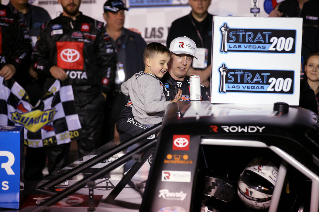 Kyle Busch and his son, Brexton, 4, apply the winner sticker to his truck after winning the Str ...