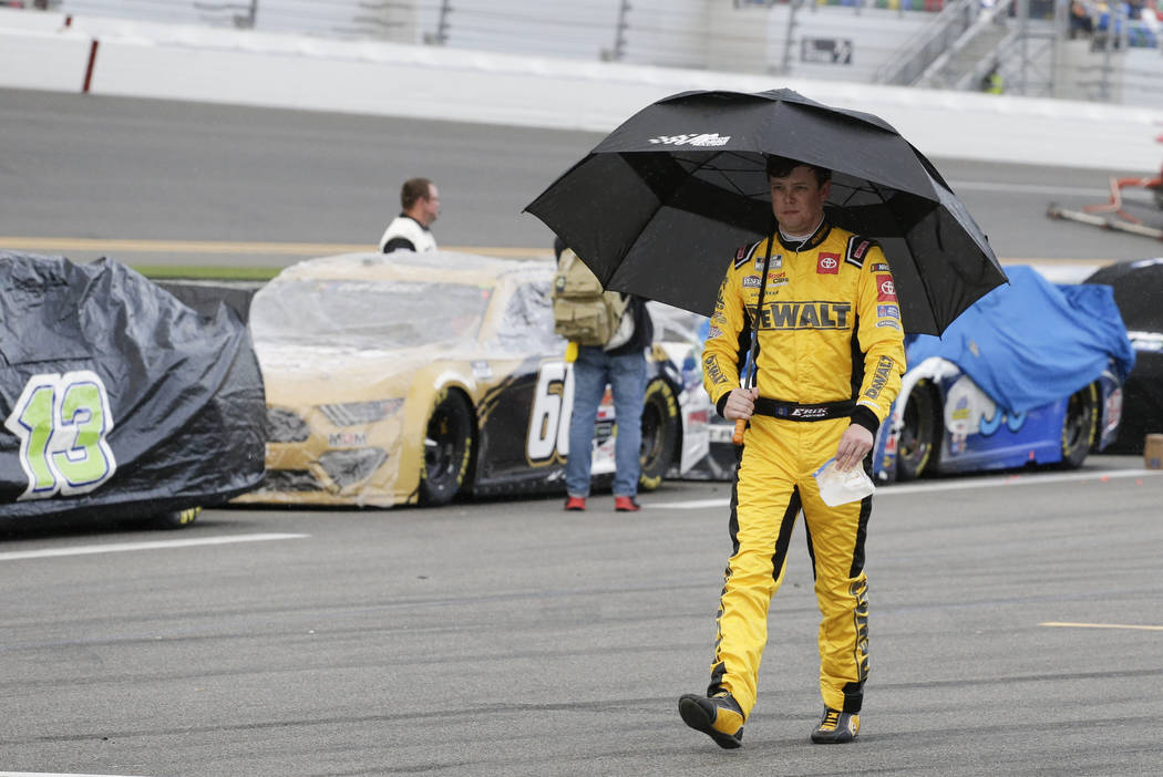 Erik Jones walks down pit road after rain caused a delay in the NASCAR Daytona 500 auto race at ...