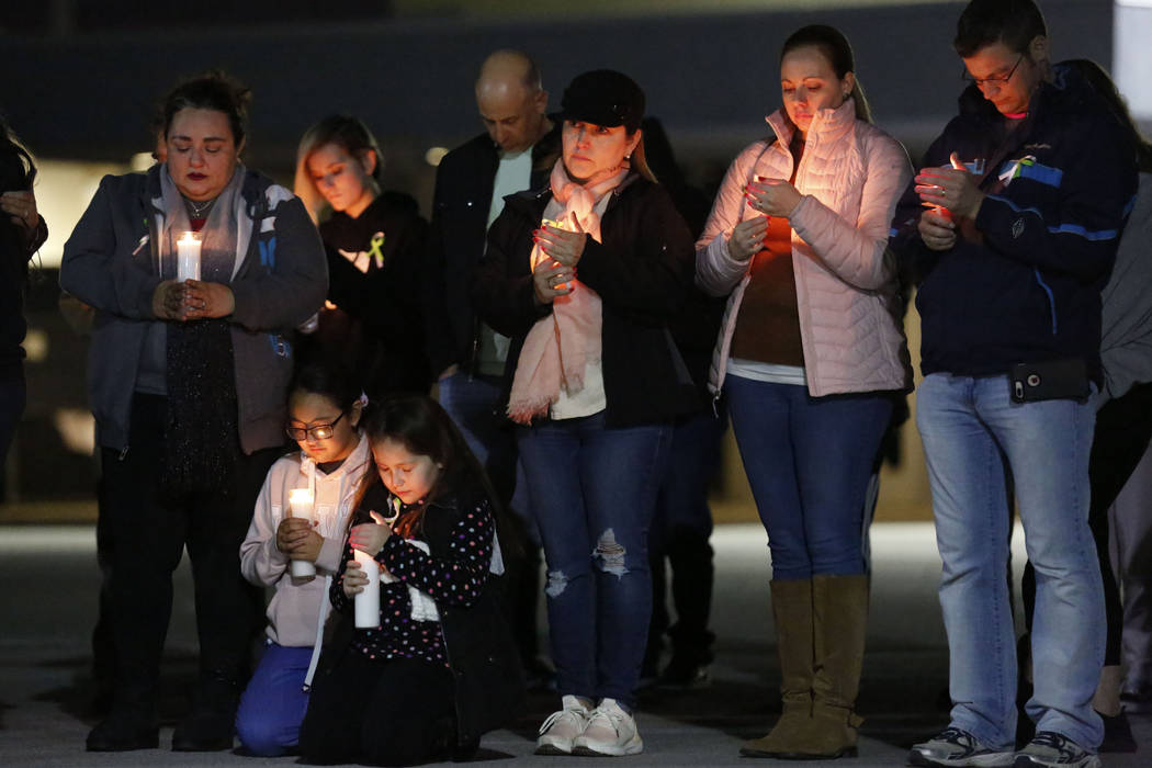Dozens of parents and students pray during a candlelight vigil at Somerset Academy in North Las ...