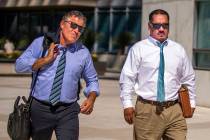 Counselor Mark Fleming, left, walks out with defendant Albert Lopez outside the Lloyd D. George ...