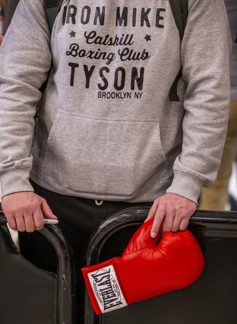 A fan holds a boxing glove in hopes of an autograph from WBC heavyweight title fighter's Tyson ...