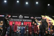 Deontay Wilder, left, stands opposite Tyson Fury, of England, during a weigh-in for their WBC h ...