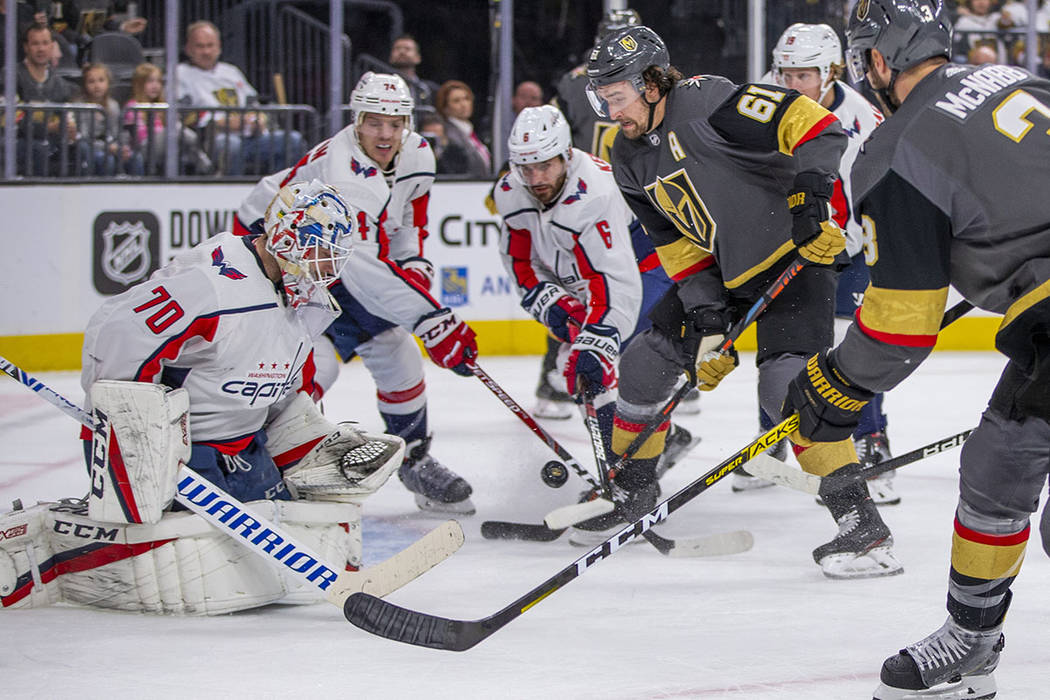 Vegas Golden Knights right wing Mark Stone (61, center) battles for a shot on Washington Capita ...