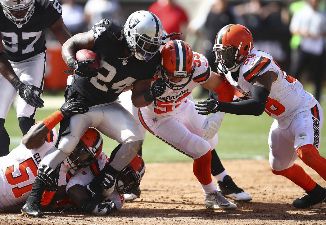 Oakland Raiders running back Marshawn Lynch (24) is stopped by Cleveland Browns outside linebac ...