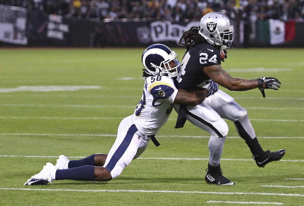 Oakland Raiders running back Marshawn Lynch is tackled by Los Angeles Rams linebacker Cory Litt ...