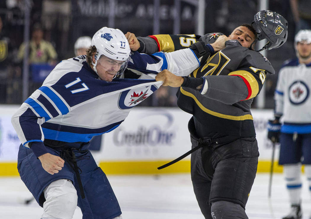 Winnipeg Jets left wing Adam Lowry (17) and Vegas Golden Knights right wing Ryan Reaves (75) sc ...