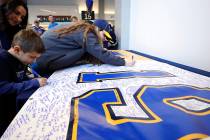 Fans sign a banner sending well wishes to St. Louis Blues' Jay Bouwmeester prior to the start o ...