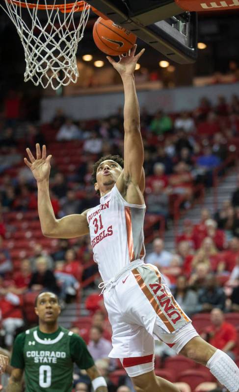 UNLV Rebels guard Marvin Coleman (31) drives over Colorado State Rams guard Hyron Edwards (0) i ...