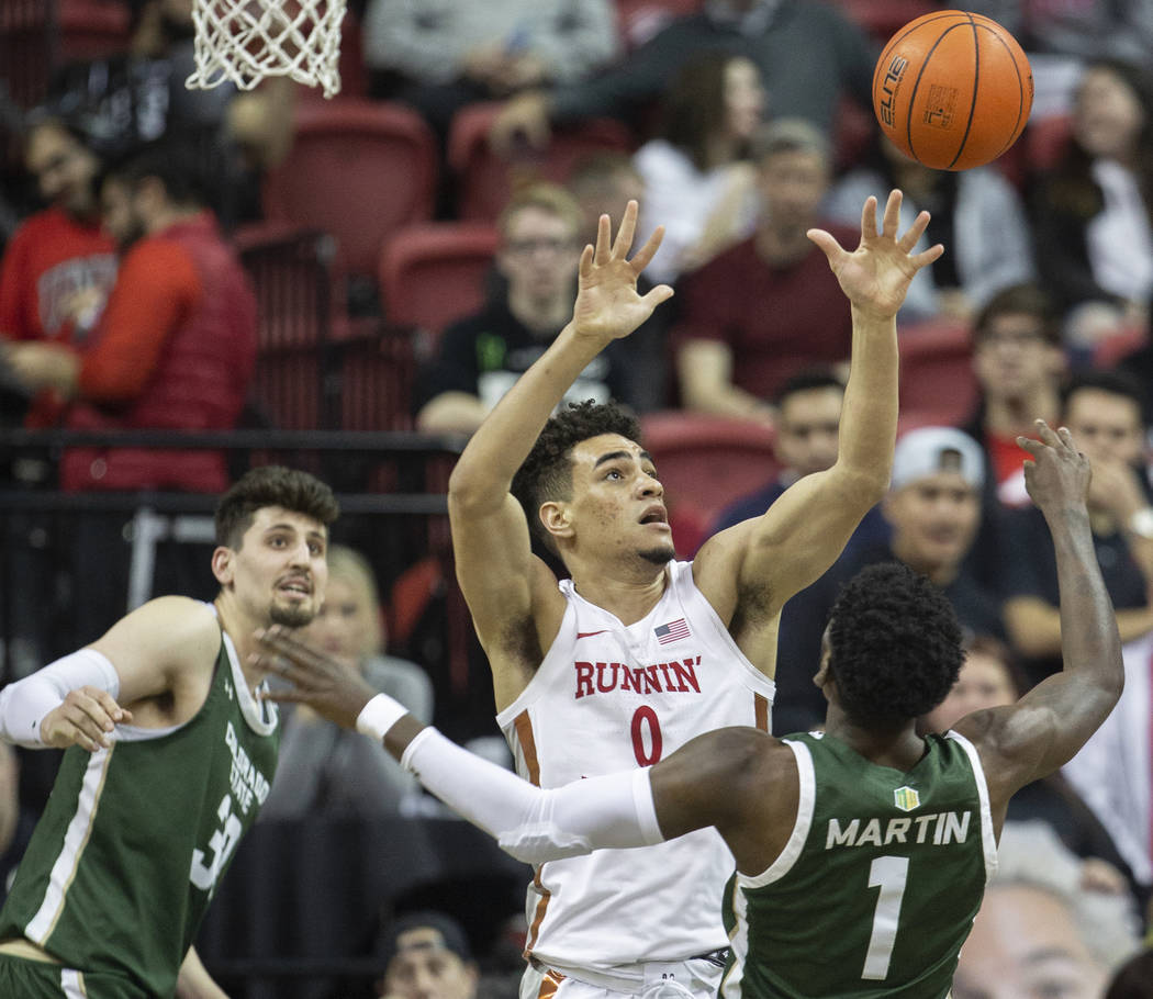 UNLV Rebels guard Jay Green (0) fights for a rebound with Colorado State Rams guard Kris Martin ...
