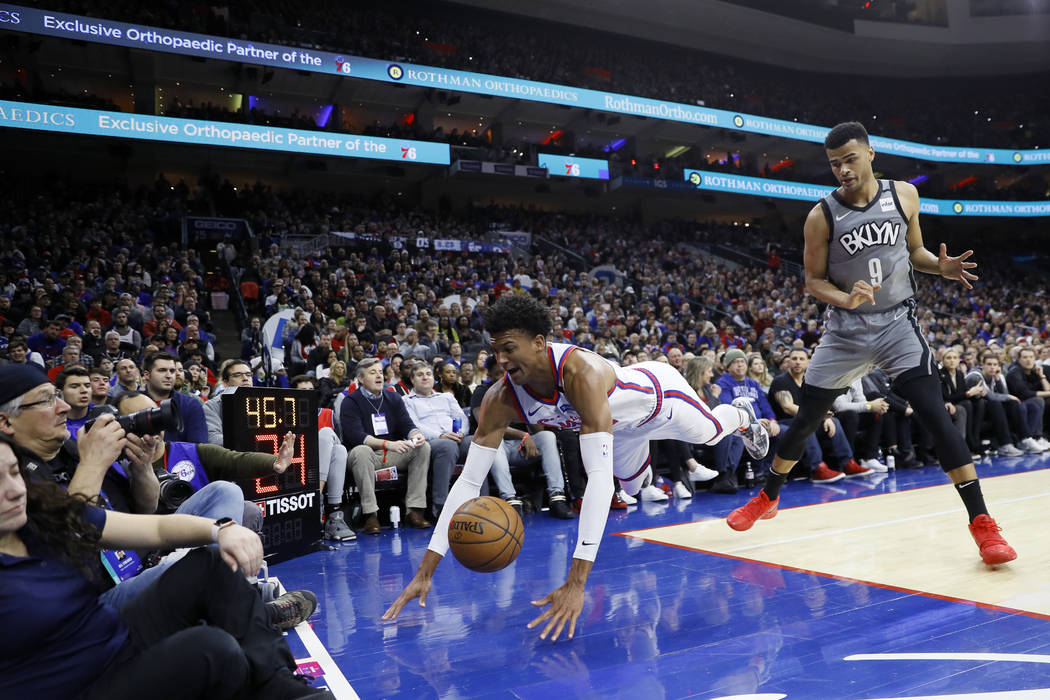 Philadelphia 76ers' Matisse Thybulle, center, dives for a loose ball past Brooklyn Nets' Timoth ...