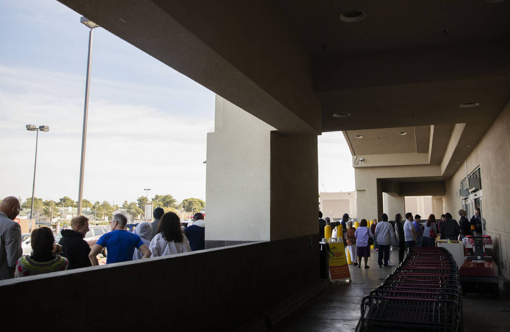 Individuals wait in line to cast their early vote at Cardenas Market in Las Vegas on Tuesday, F ...