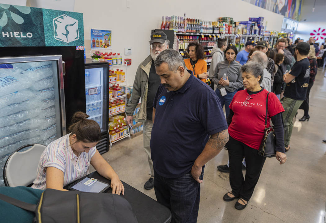 Individuals sing in to cast their early vote at Cardenas Market in Las Vegas on Tuesday, Feb. 1 ...