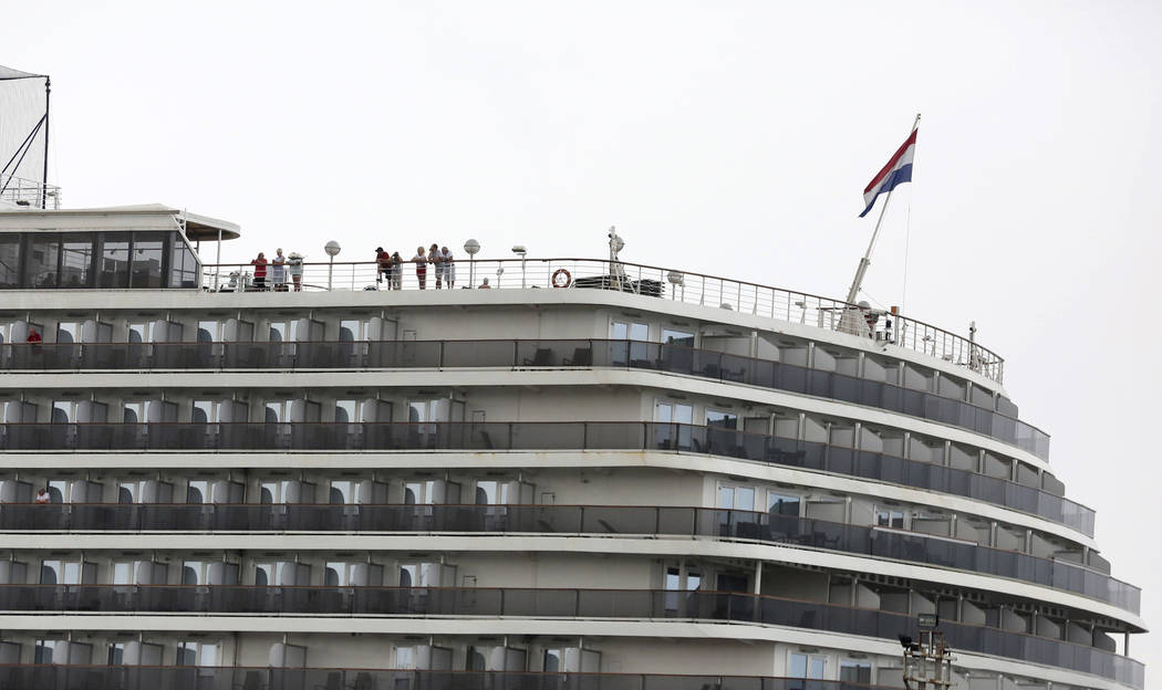 Passengers stand on the top deck of the MS Westerdam while the cruise ship is docked in Sihanou ...